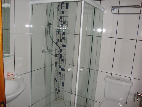 a bathroom with a shower and a toilet and a sink at Pousada Serra do Jordão by Concavus in Campos do Jordão