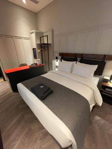 a bedroom with a large bed with a black bag on it at Junibino Hotel Hongdae in Seoul