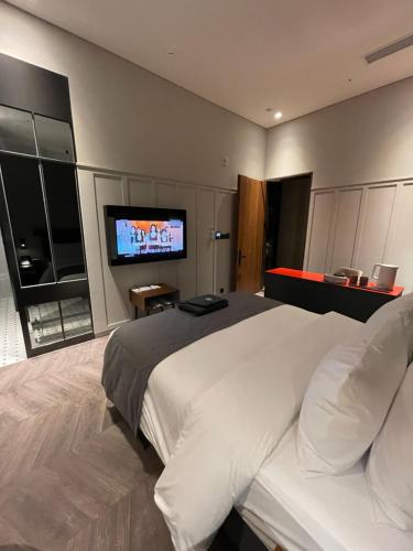 a bedroom with a large bed and a flat screen tv at Junibino Hotel Hongdae in Seoul