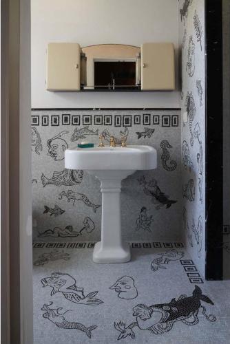 a bathroom with a sink and a mirror at The House in Strevi