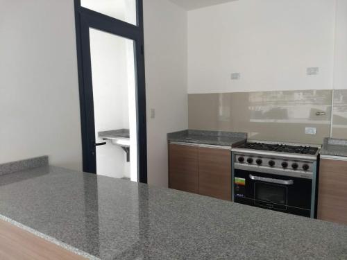 a kitchen with a stove and a counter top at Departamento centro Carlos Paz in Villa Carlos Paz
