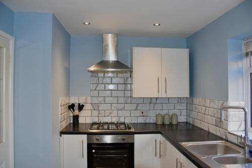 a kitchen with a stove top oven next to a sink at 2 Bedroom semi-detached house Luton in Luton