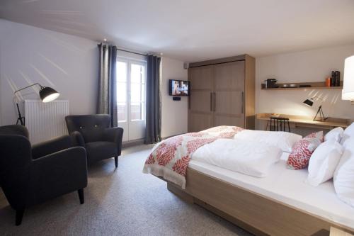 a bedroom with a bed and a desk and a chair at Hotel Berghof in Lech am Arlberg