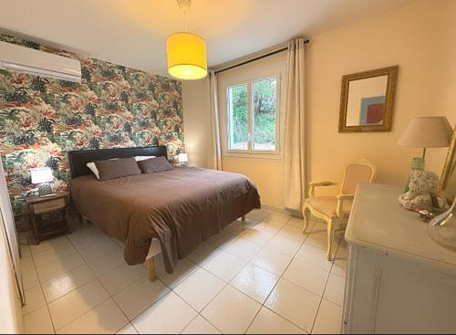 une chambre avec un lit, une table et une fenêtre dans l'établissement Le Mas Saint Jean en PACA, à Les Mayons