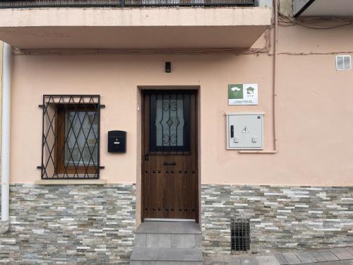 a building with a wooden door and a window at Casa Rural Renueva en Buendía in Buendía