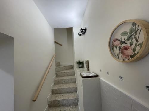 a staircase in a house with a clock on the wall at Casa Rural Renueva en Buendía in Buendía