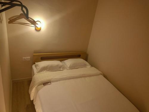 a small bed with two white pillows in a room at Keteri Boutique Hotel in Kangar