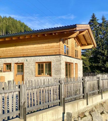 a house with a wooden fence in front of it at Wieslhütte in Gerlosberg