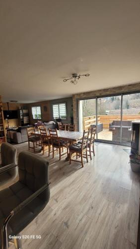 un grand salon avec une table et des chaises dans l'établissement Gîte Le Canaillou, à Xonrupt-Longemer