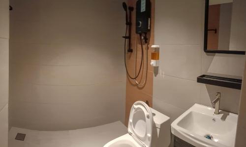 a bathroom with a toilet and a sink at Keteri Boutique Hotel in Kangar