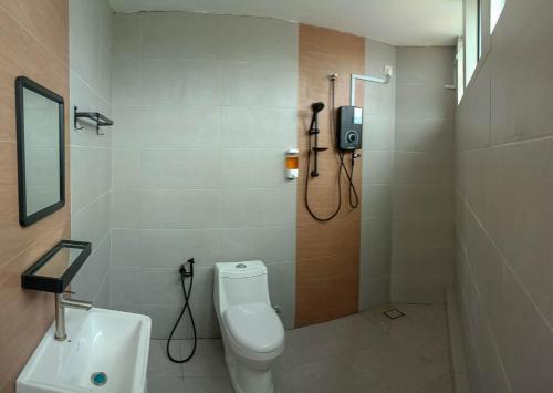 a bathroom with a shower and a toilet and a sink at Keteri Boutique Hotel in Kangar