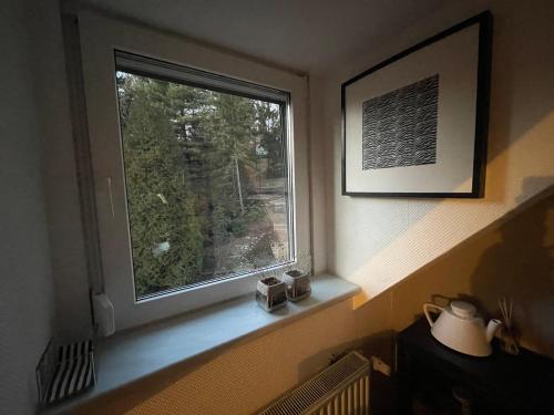 a window with two clocks sitting on a window sill at Modernes 1-Raum-Apartment in Dresden
