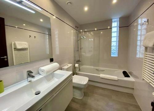 a bathroom with a sink and a tub and a toilet at Villa Lux Mar in Cala Llena