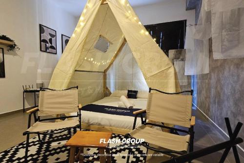 a bedroom with a tent and two chairs and a table at Forte Seasons Mossaz Premium Suites Petaling Jaya in Petaling Jaya