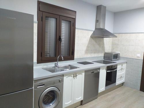 una cocina con fregadero y lavadora en Carreras Beach Candeleda Casa en piscina natural, en Candeleda