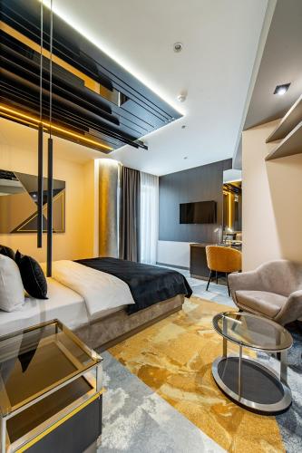 a bedroom with a king sized bed and a living room at Hotel Ženeva Lux in Kragujevac
