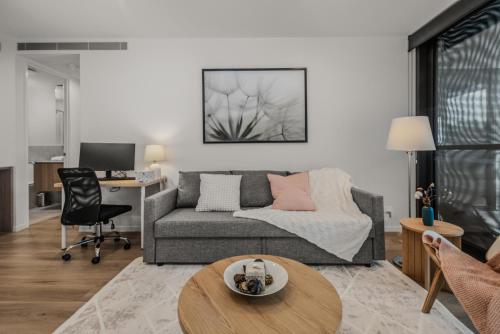 a living room with a couch and a table at "The Mowbray"-Luxury,rooftop pool,gym,free parking in Brisbane