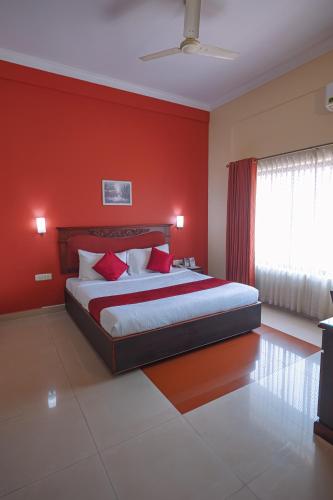 a red bedroom with a bed with red walls at CLUB7 HOTEL in Thiruvalla