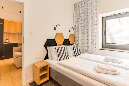 Un dormitorio con una gran cama blanca con ventana. en Boho Łeba z basenem krytym i jacuzzi, en Łeba