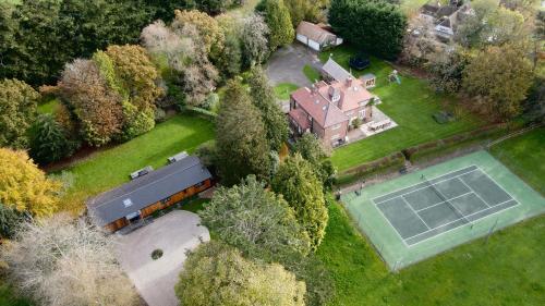 an aerial view of a house with a tennis court at Hedgerows House New Forest in Ringwood