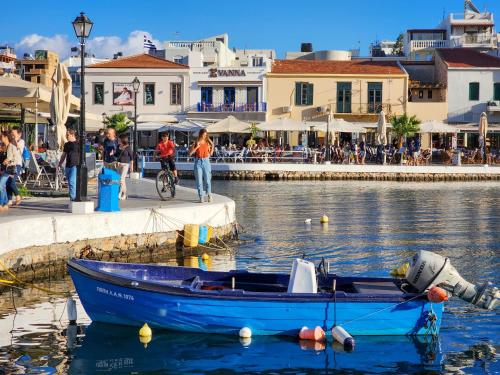 a blue boat in the water next to a harbor at Hotel Port 7- Boutique Collection in Agios Nikolaos