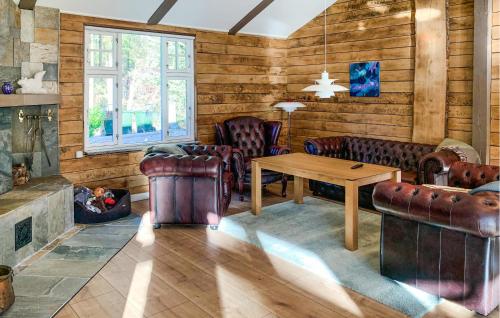 a living room with leather furniture and a fireplace at Lovely Home In Ebeltoft in Ebeltoft