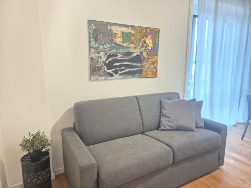 a couch in a living room with a painting on the wall at Centro Lecco Piazza Manzoni in Lecco
