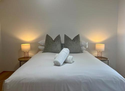 a white bed with two pillows and two lamps at Stylish Armadale Getaway in Armadale