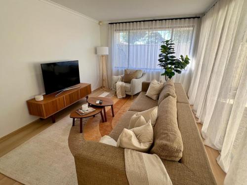 a living room with a couch and a tv at Stylish Armadale Getaway in Armadale