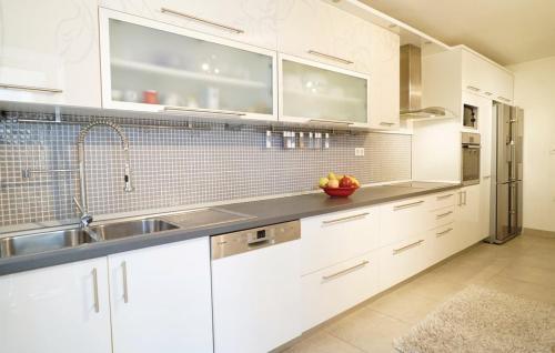 una cucina con mobili bianchi e un lavandino di Villa Majanko a Zmijavci