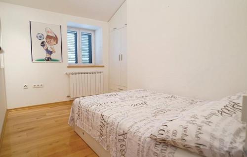 una camera da letto bianca con un letto e una finestra di Villa Majanko a Zmijavci