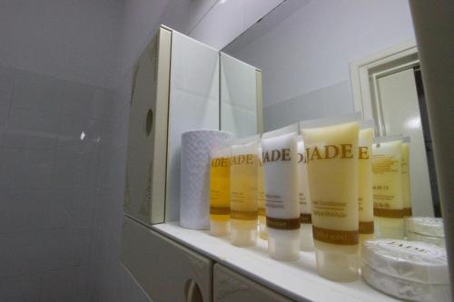 a bathroom shelf with a bunch of toiletries in front of a mirror at Large Veranda 2BR Walk to Beach in Paralimni