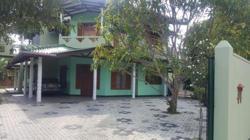 a green house with a tree in front of it at Calm Casita Luxury Villa in Matara in Matara