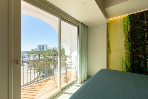 a bedroom with a large window and a balcony at The White Apartments in San Antonio