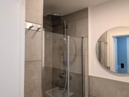 a bathroom with a shower with a glass door at Schmucke-Huus-Bungalow in Westerland (Sylt)