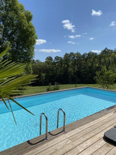 - une piscine à côté d'une terrasse en bois dans l'établissement Chalet Enchante Nature, à Saint-Aulaire