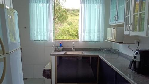 una cucina con un lavandino e una finestra di Casa Completa com Varanda Garagem Wi fi Suíte a São João del Rei