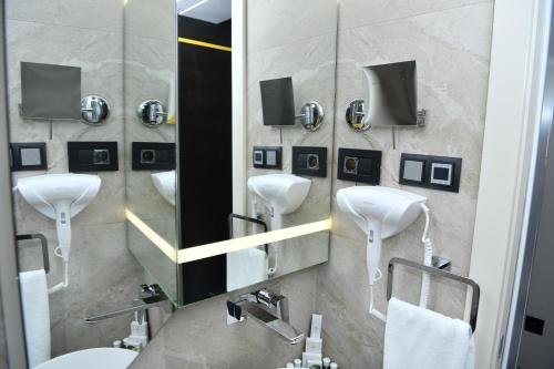 a bathroom with two sinks and a mirror and a sink at Hotel Ženeva Lux in Kragujevac