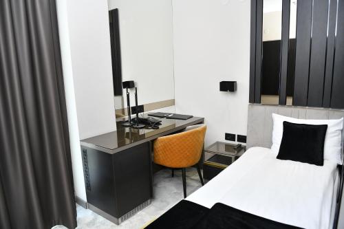 a bedroom with a desk and a bed and a desk at Hotel Ženeva Lux in Kragujevac