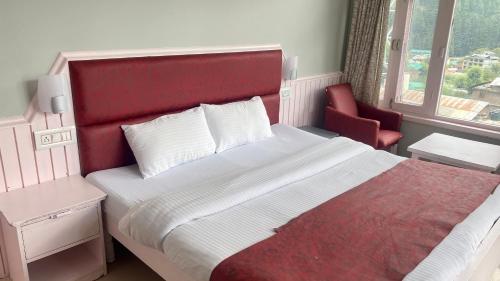 a bedroom with a large bed with a red headboard at Hotel Meadows & Hotel Ocean Edge ! Family Hotel ! A couple Hotel ! Near to Hadimba Temple in Manāli