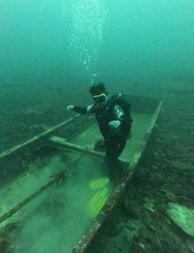 a man in a wetsuit standing on a platform in the water at Alab in Mabini