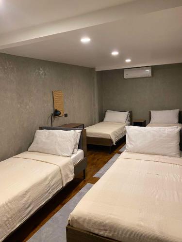 a room with three beds in it at Alab in Mabini