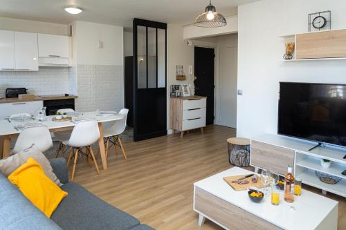 un salon et une cuisine avec un canapé et une table dans l'établissement L'escapade Paloise, Balcon, Garage privé, à Pau