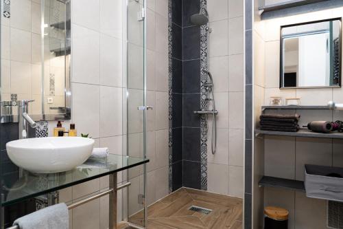 une salle de bain avec un lavabo et une douche en verre dans l'établissement L'escapade Paloise, Balcon, Garage privé, à Pau