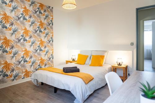 une chambre avec un lit avec des oreillers jaunes dans l'établissement L'escapade Paloise, Balcon, Garage privé, à Pau