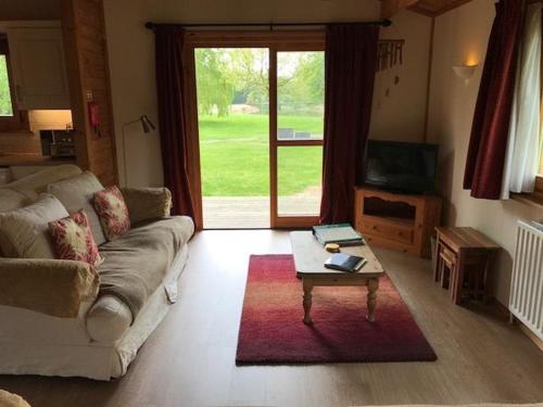 a living room with a couch and a coffee table at Teal Lodge in Market Rasen