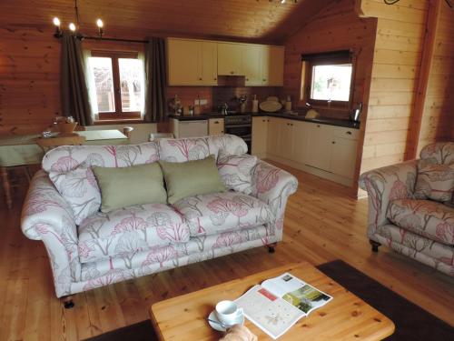 a living room with a couch and a table at Woodpecker Lodge in Market Rasen