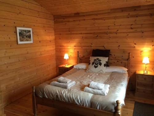 a bedroom with a bed in a log cabin at Woodpecker Lodge in Market Rasen