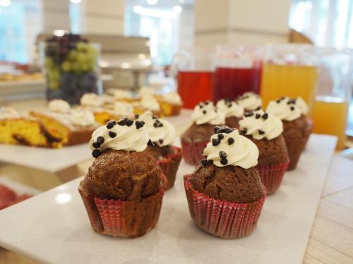 a row of cupcakes with whipped cream on them at Michelangelo Cesenatico in Cesenatico