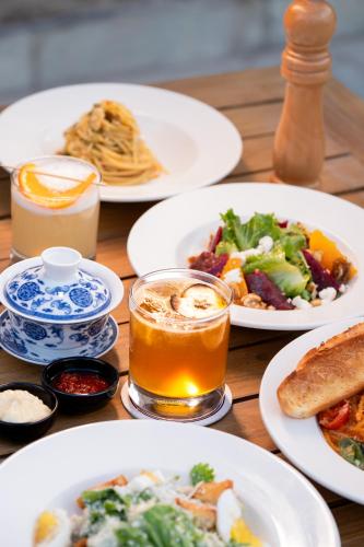 a table with plates of food and a glass of beer at Chospa Hotel, Leh in Leh